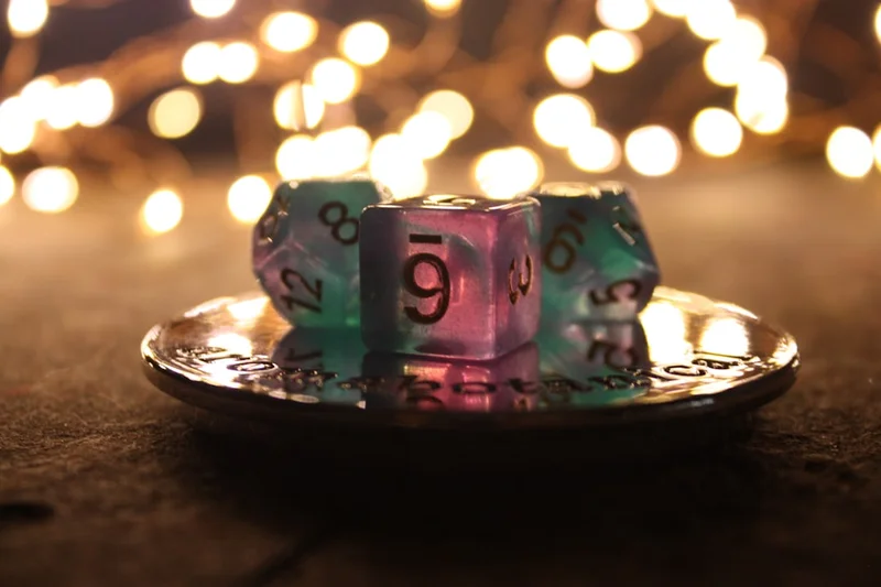 Dice sit in a dish with string lights in the background.
